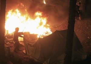 Riot police set fire to tents pitched by anti-Mursi demonstrators at Tahrir Square in Cairo