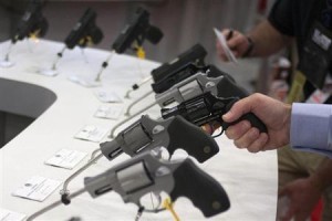 Man holds a gun in the exhibit hall of the George R. Brown Convention Center, the site for the NRA's annual meeting in Houston, Texas