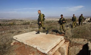 Israeli soldiers walk near Alonei Habashan close to the Israeli-Syrian border in the Golan Heights